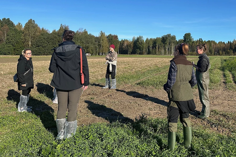 Finley Blackburn står på en åker tillsammans med tjänstemän och politiker från Säters kommun