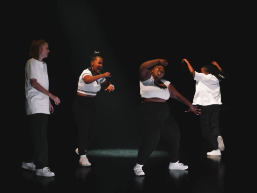 Scenisk bild från dansföreställningen Groove. 4 tjejer poserar i olika streetdans-positioner